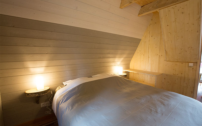 Room with double bed in the chalet, rented at the campsite Les Murmures du Lignon in Haute-Loire