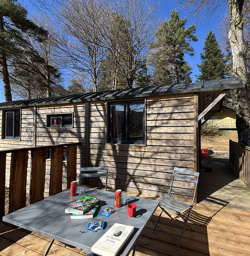 Exterior view of the Roulotte with terrace, unique accommodation in Auvergne, for rent at Les Murmures du Lignon campsite